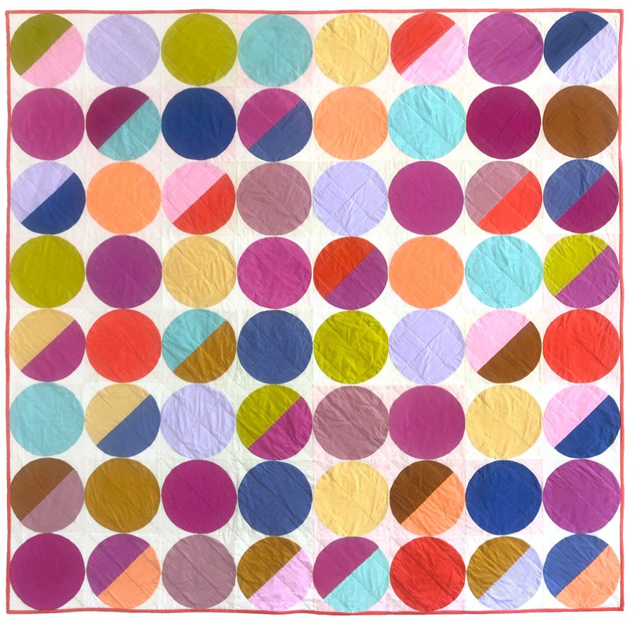 a quilt made of circles in multiple colors