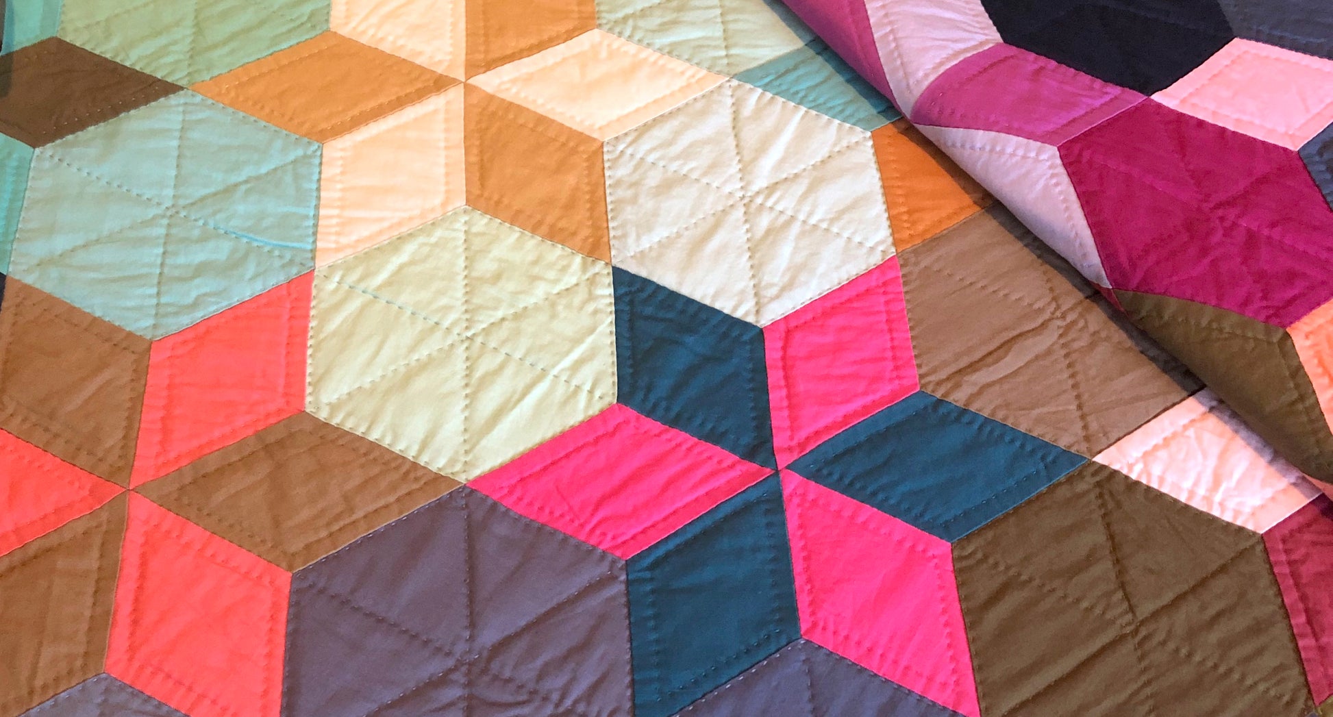 Hand sewn and quilted star quilt in multiple colors with a dark blue background.